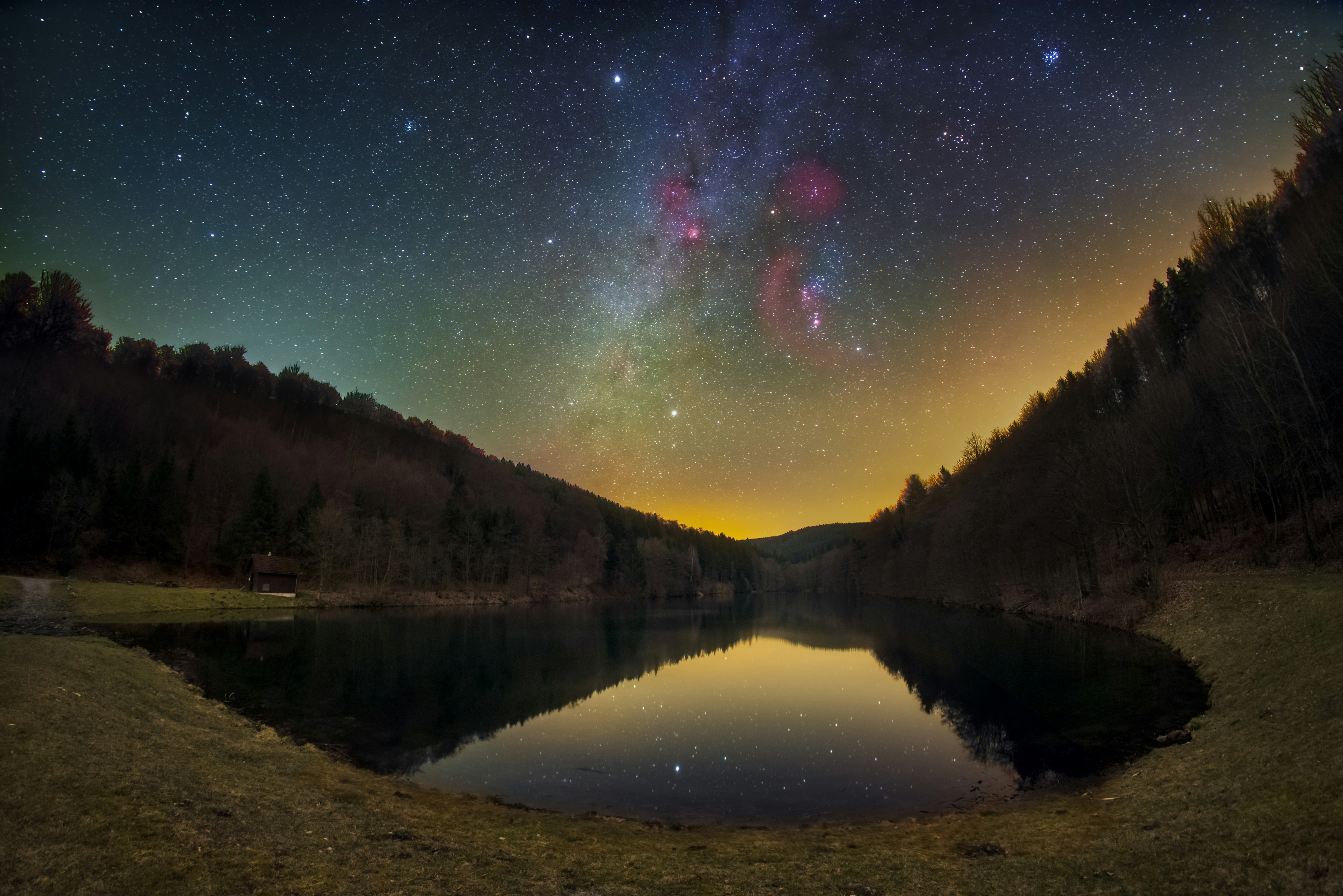 Photograph of a mountain lake, with the stars shining from above.